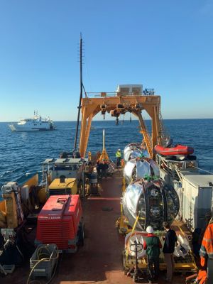 Four detection units in their deployment frame on the boat awaiting deployment. The second boat in the background manages the operation of the remotely operated submersible.